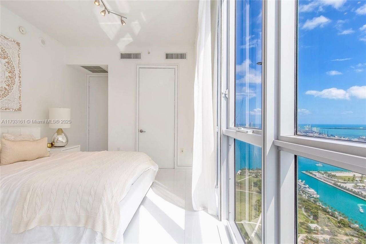 1121 Crandon Boulevard, Unit D802 Key Biscayne, FL 33149 - Photo 28 of 30 a bedroom with a bed and a window