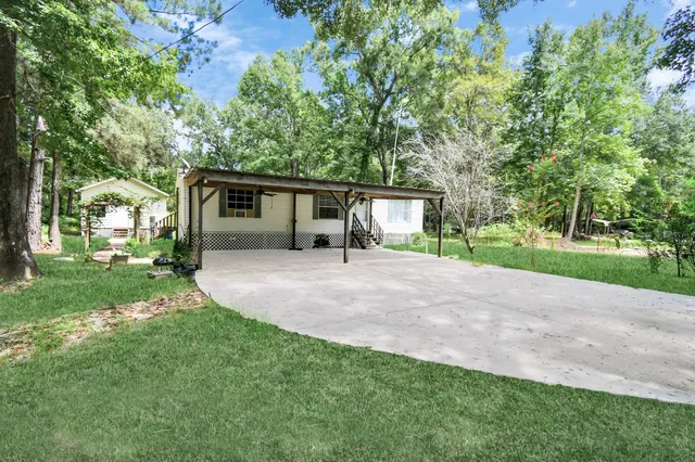front view of a house with a yard and potted plants