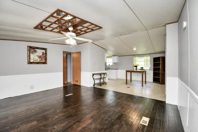 a view of a livingroom with wooden floor and a ceiling fan