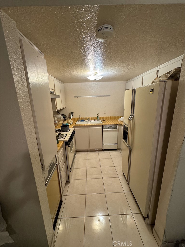 3700 Missouri Street West Covina, CA 91792 - Photo 8 of 14 a kitchen with granite countertop stainless steel appliances a sink and a refrigerator