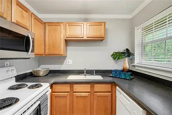 a kitchen with stainless steel appliances granite countertop a sink a stove and a microwave