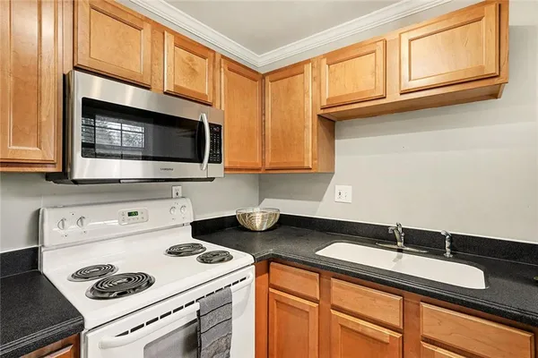 a kitchen with stainless steel appliances granite countertop a sink stove and microwave