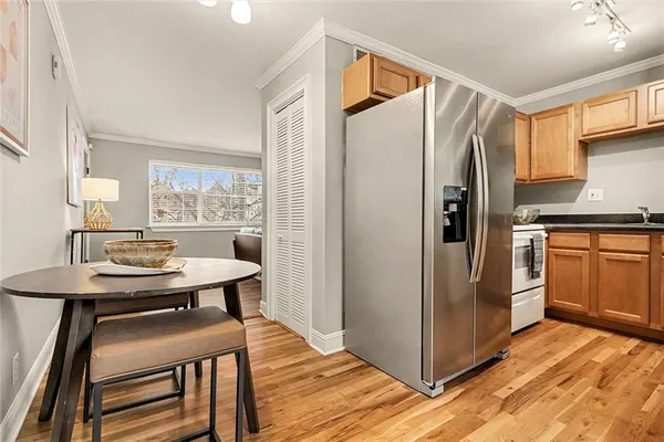 a kitchen with stainless steel appliances a refrigerator a sink a stove and white cabinets