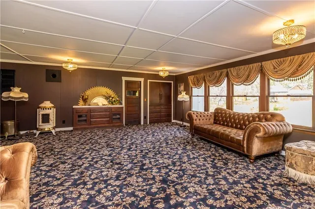 a view of a backyard with table and chairs plants and large trees