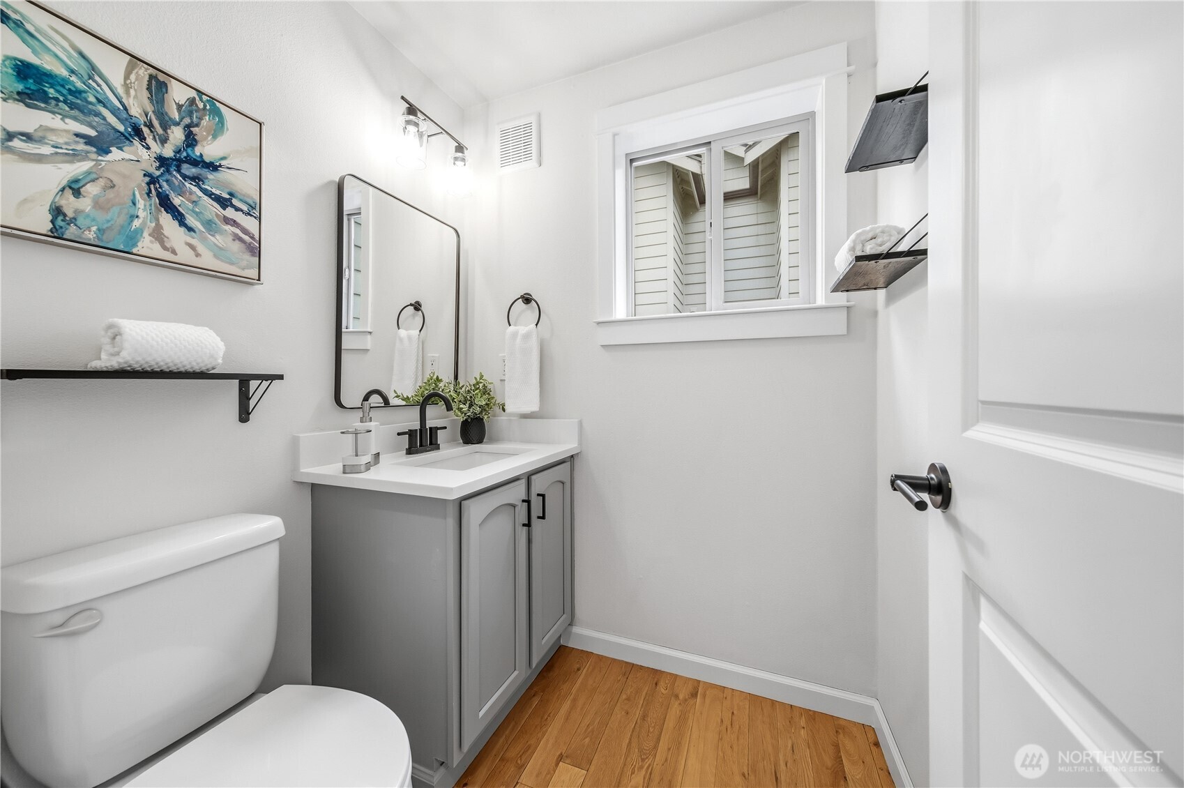 1122 North 92nd Street, Unit B Seattle, WA 98103 - Photo 12 of 28 a bathroom with a toilet a sink and mirror