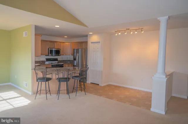 a view of kitchen with kitchen island and stainless steel appliances