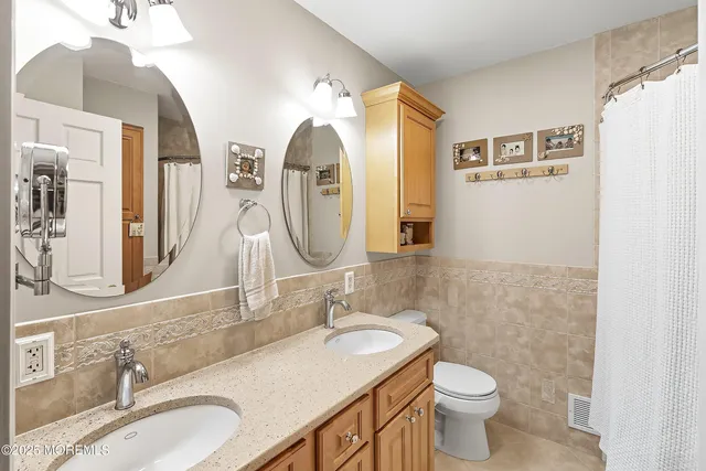 a bathroom with a granite countertop sink mirror and a toilet