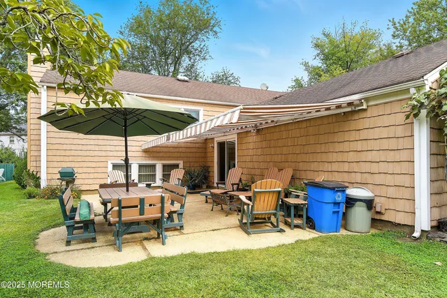 a view of a patio with table and chairs under an umbrella