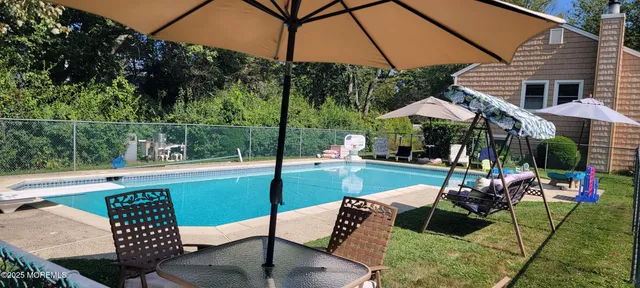 a view of a patio with table and chairs under an umbrella