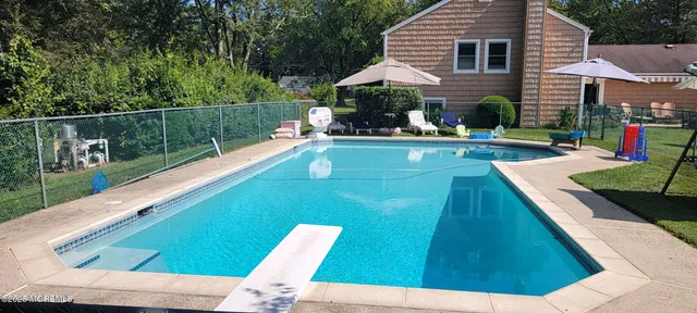 a view of house with swimming pool outdoor seating