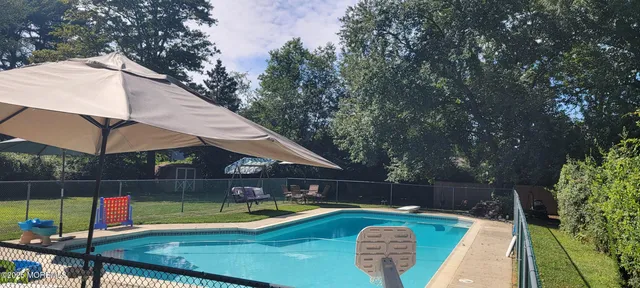 a view of a backyard with swimming pool and sitting area