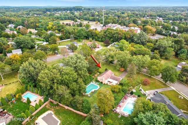 an aerial view of residential houses with outdoor space and trees