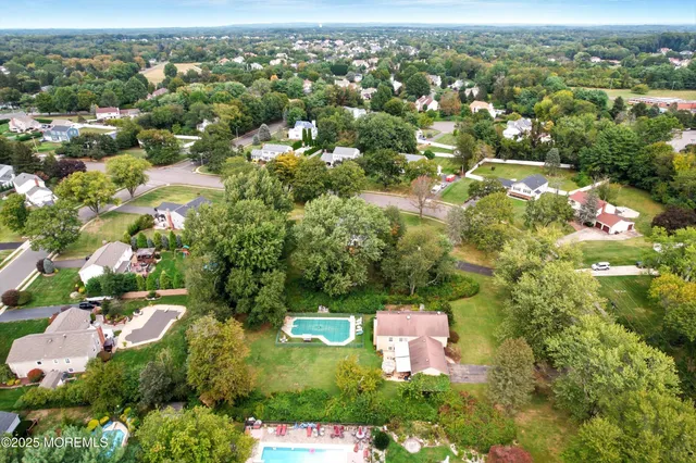 an aerial view of residential houses with outdoor space and trees