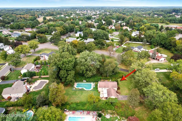 an aerial view of residential houses with outdoor space and trees