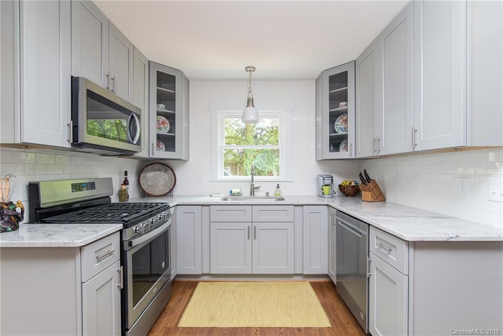2431 Eaton Road Charlotte, NC 28205 - Photo 13 of 19 a kitchen with stainless steel appliances granite countertop a sink a stove a microwave cabinets and a window