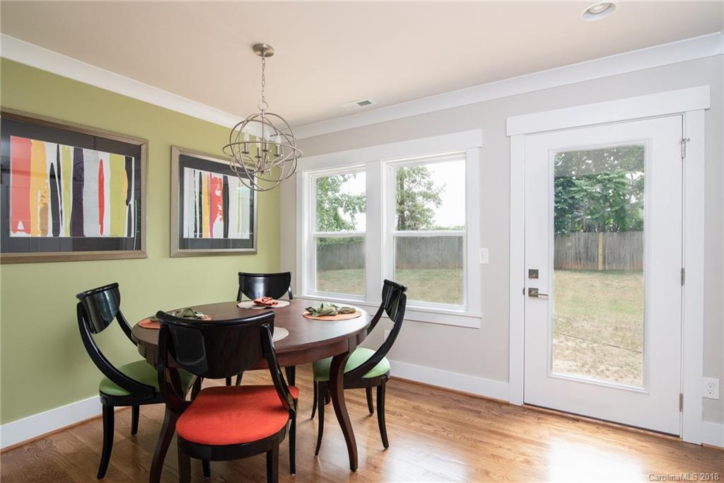 2431 Eaton Road Charlotte, NC 28205 - Photo 16 of 19 a dining room with furniture a chandelier and wooden floor