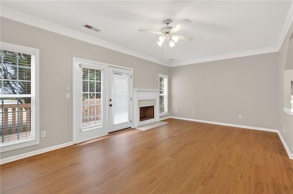1186 Lake Point Way Suwanee, GA 30024 - Photo 15 of 35 a view of an empty room with chandelier fan and fire place