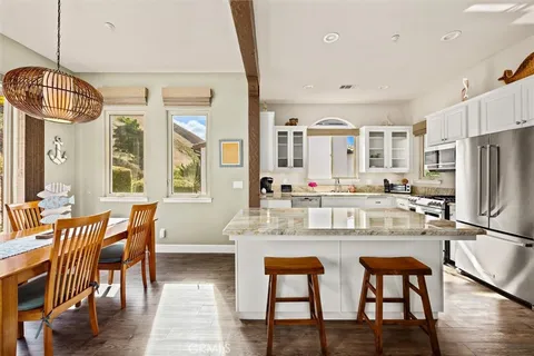 a kitchen with stainless steel appliances granite countertop a dining table chairs and granite counter tops