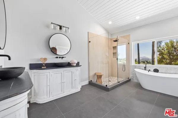 a bathroom with a double vanity sink a mirror and a bathtub