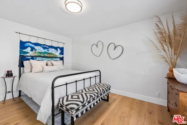 a bedroom with a bed and wooden floor