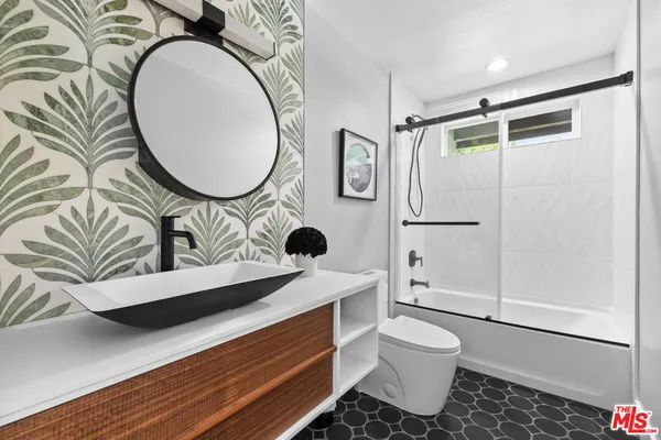 a bathroom with a toilet a sink and mirror