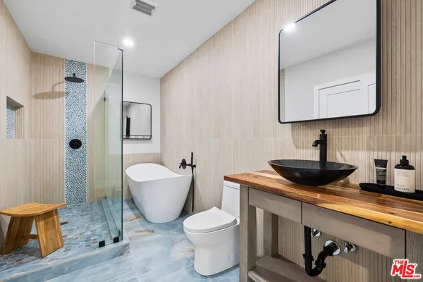 a bathroom with a granite countertop toilet sink and mirror