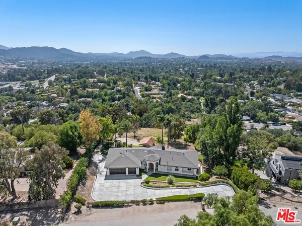 a view of a house with a yard and mountains