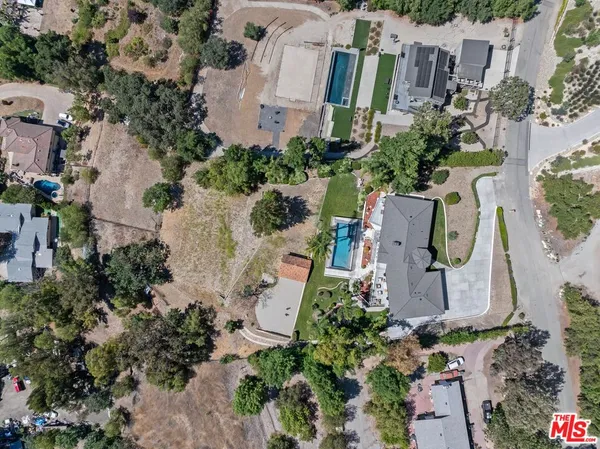 an aerial view of residential houses with outdoor space and parking