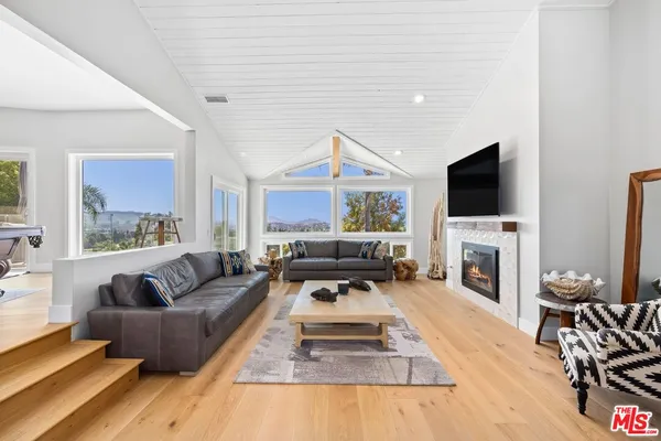 a living room with furniture a fireplace and a flat screen tv