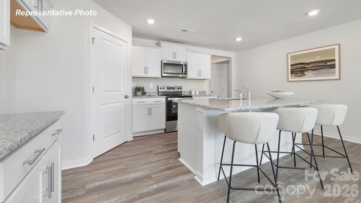 435 Frozen Dream Road Salisbury, NC 28147 - Photo 2 of 20 a large kitchen with stainless steel appliances granite countertop a stove a sink a dining table and chairs