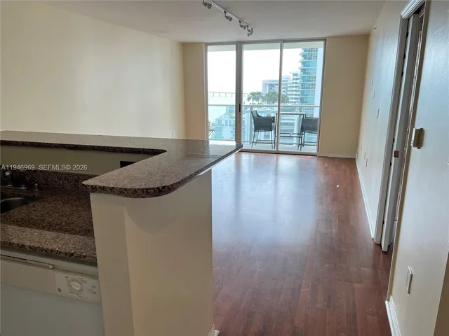 en empty room with wooden floor and fan