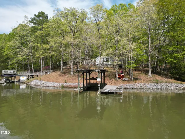 a house with swimming pool and trees in the background
