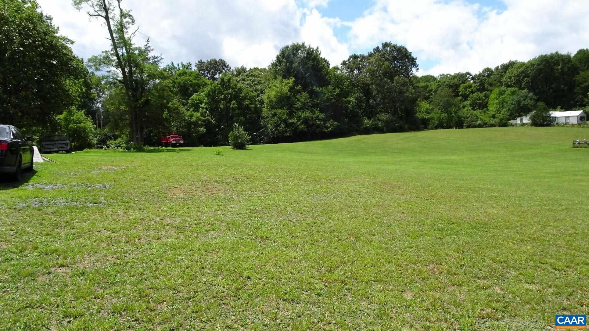 a view of a field of grass and trees