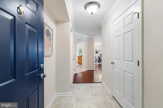 a living room with furniture a rug kitchen view and a chandelier