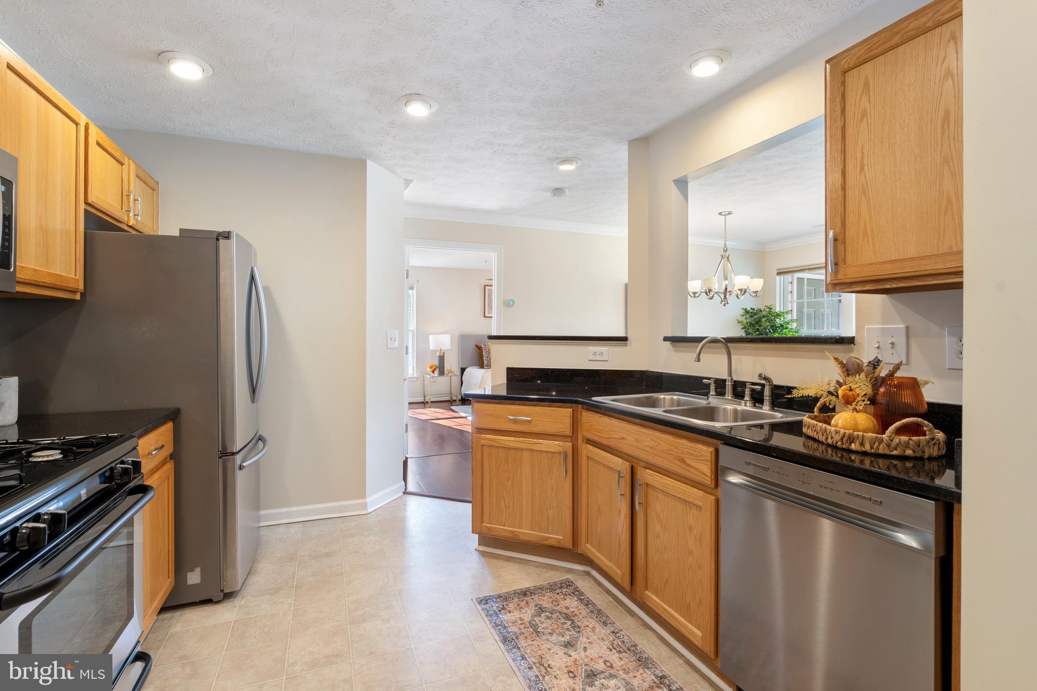 9602 Haven Farm Road, Unit 9602B Perry Hall, MD 21128 - Photo 23 of 37 a kitchen with stainless steel appliances a sink stove refrigerator and cabinets