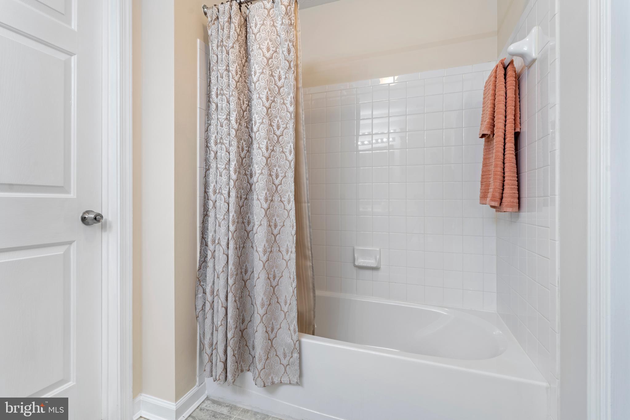 9602 Haven Farm Road, Unit 9602B Perry Hall, MD 21128 - Photo 30 of 37 a bathroom with a shower curtain and a bathtub