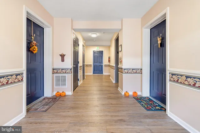 a view of a hallway with wooden floor and furniture