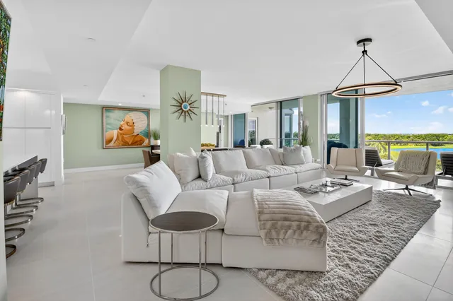 a living room with furniture a dining table and a chandelier
