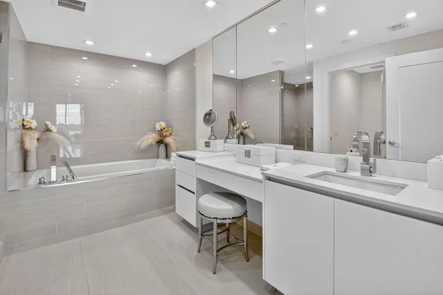 a bathroom with a double vanity sink a mirror and a bathtub