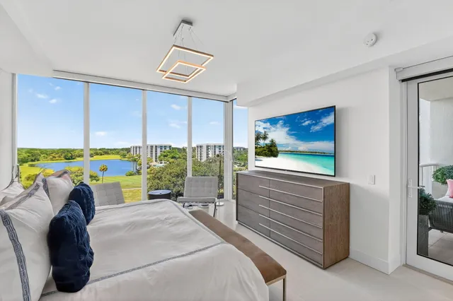 a bedroom with a bed a computer on the wall and a large window