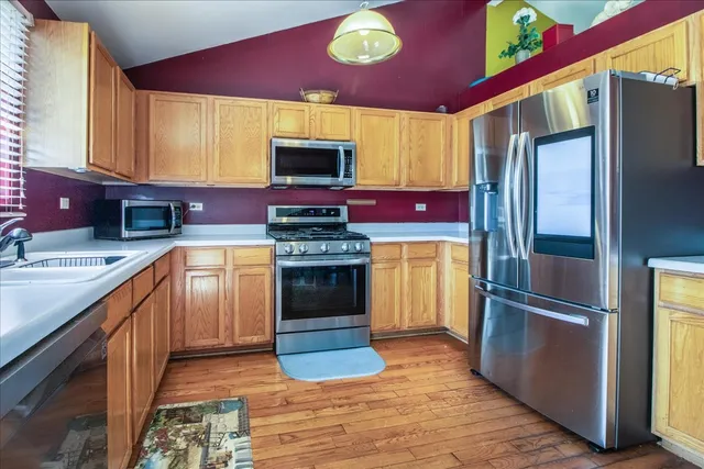 a kitchen with stainless steel appliances granite countertop a refrigerator stove and sink