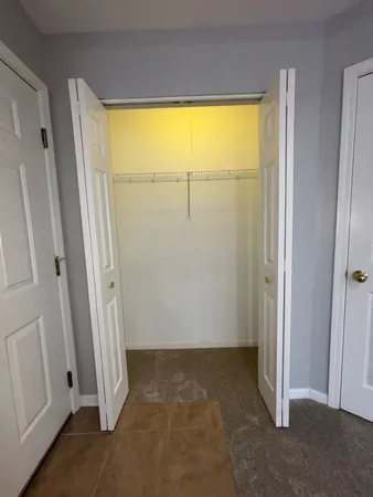 an empty room with wooden door and a window