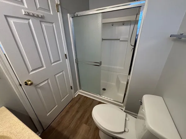 a bathroom with a granite countertop sink toilet and shower