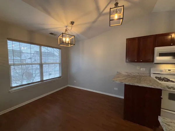 a kitchen with stainless steel appliances granite countertop a stove a sink dishwasher and a microwave oven with wooden floor