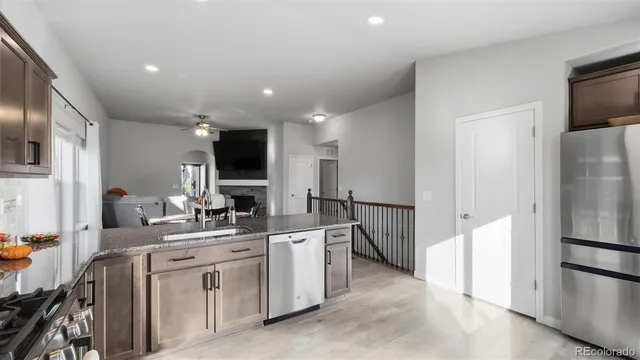 a large white kitchen with a refrigerator and a sink