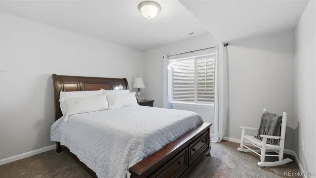 a bedroom with a bed chair and window