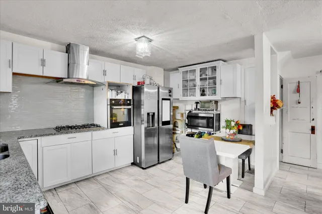 a kitchen with stainless steel appliances a stove a sink refrigerator and a refrigerator