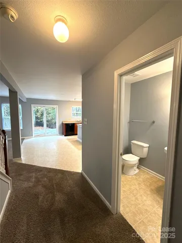 a large white bed in a white room with a large mirror