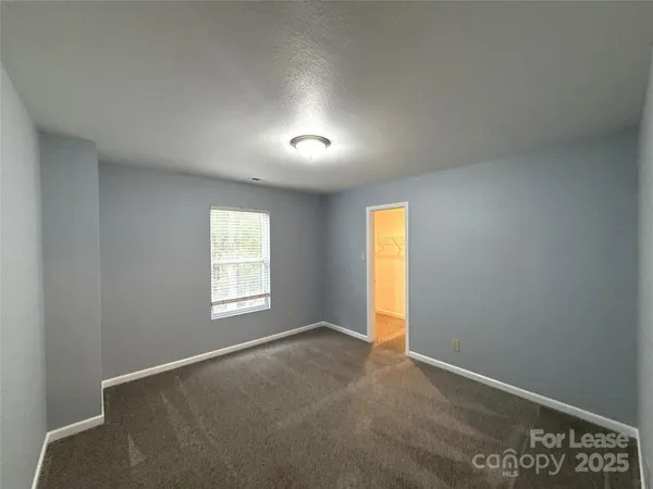 an empty room with a window and wooden floor