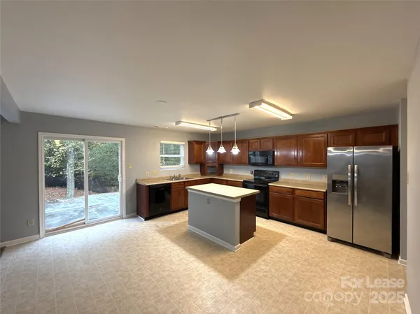 a kitchen with granite countertop a refrigerator and a stove top oven